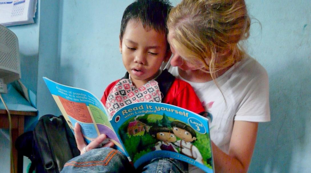 A student on the Physiotherapy internship for high school students in Nepal, reads to a young child. A child and Projects Abroad student read a book on the Physiotherapy internship for teenagers in Nepal.